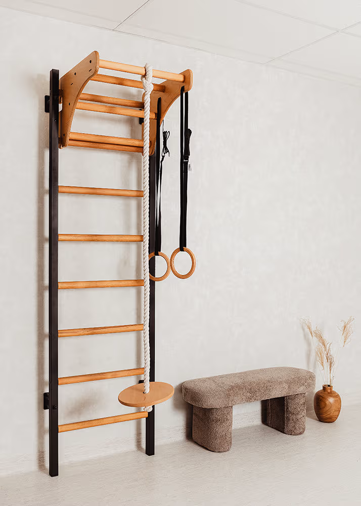 BenchK wall bar with gymnastic rings, climbing rope, and trapeze — a home gymnastics practice setup