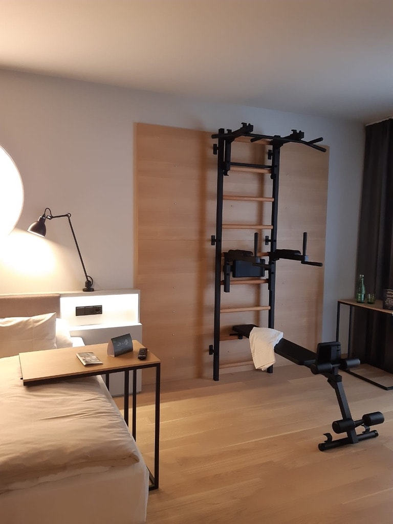 BenchK Series 7 wall bar installed in a hotel-style suite — black powder-coated steel and beech
