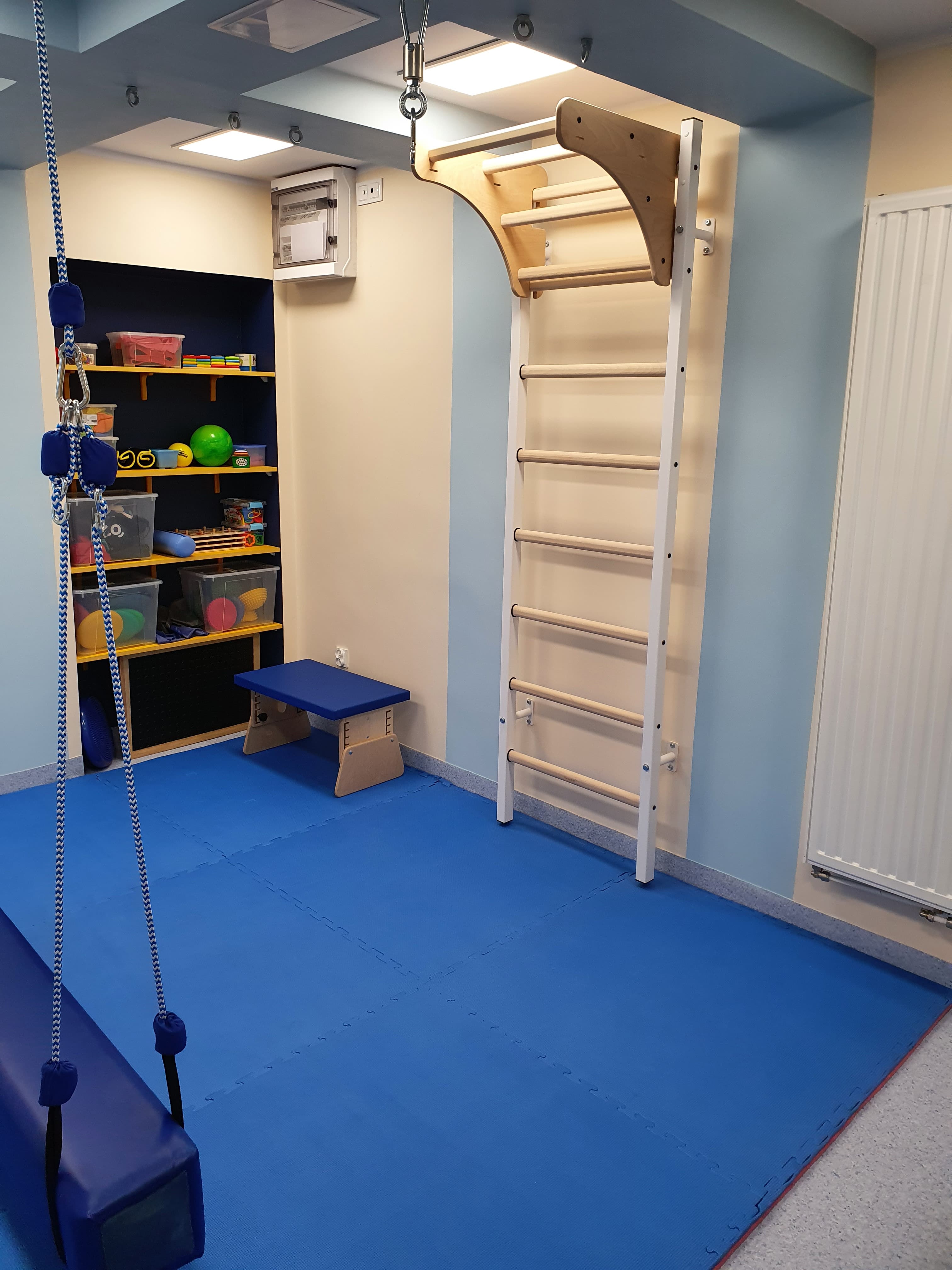 Wall bars mounted to the ceiling with a rope and pulley system in a pediatric physiotherapy clinic