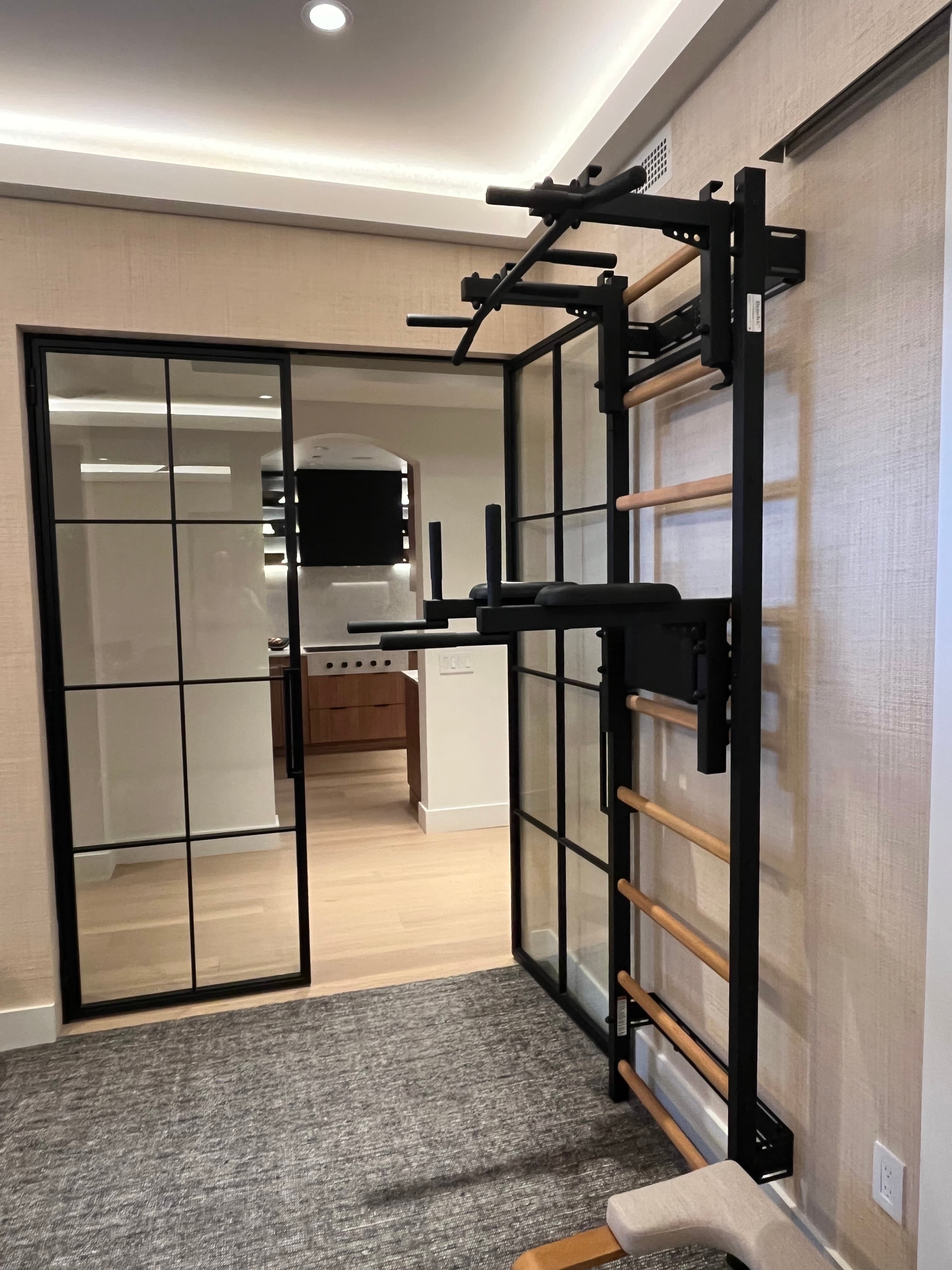 Close-up from below of a BenchK pull-up and dip bar attachment bolted to wall bar rungs