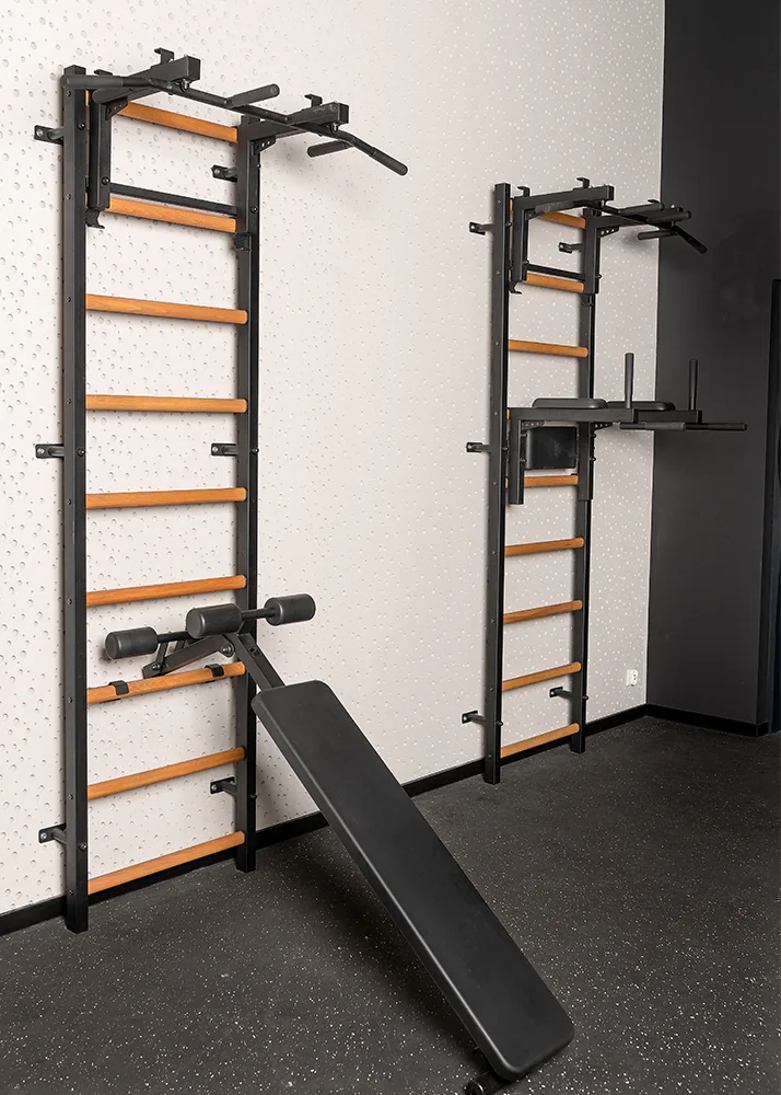 BenchK wall bars with the pull-up bar, dip station, and bench installed in a gym